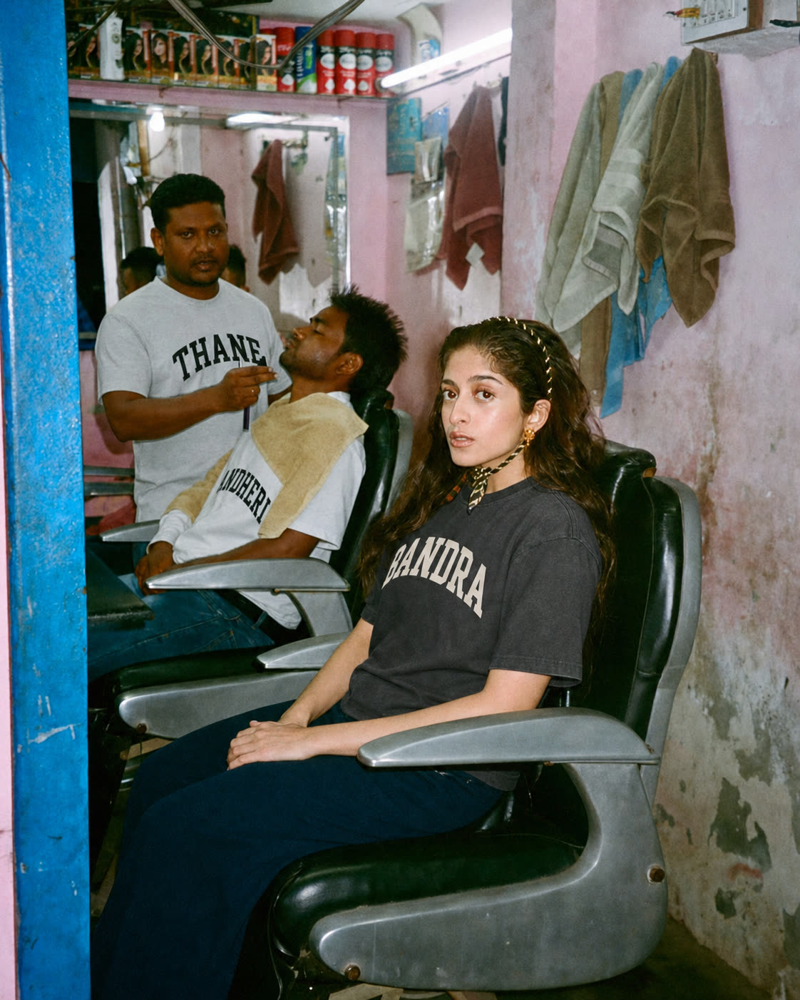 Three people in a barbershop wearing Thane and Bandra tees