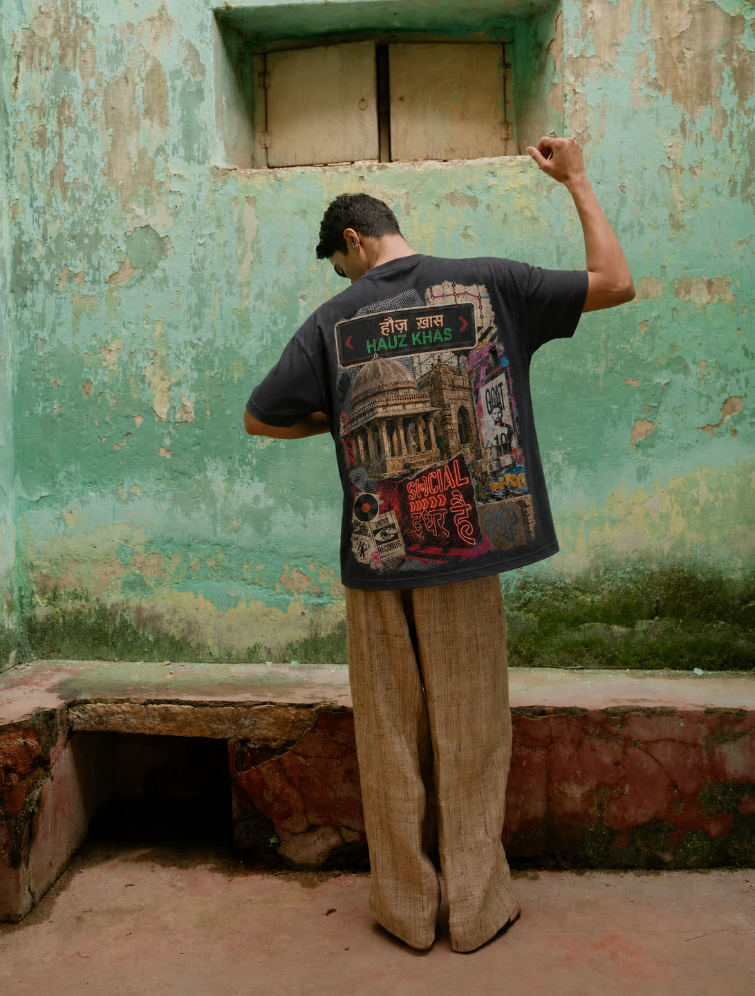 Back view of the Hauz Khas tee against a green wall